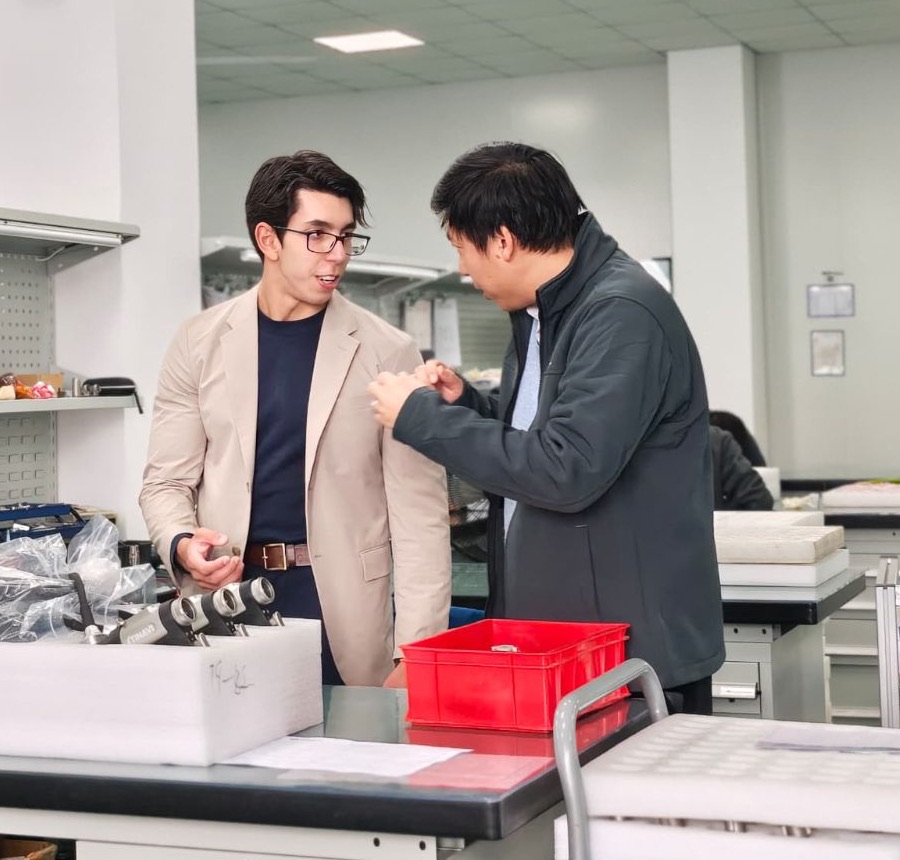 Nando Voyager conversando com um parceiro em uma fábrica na China